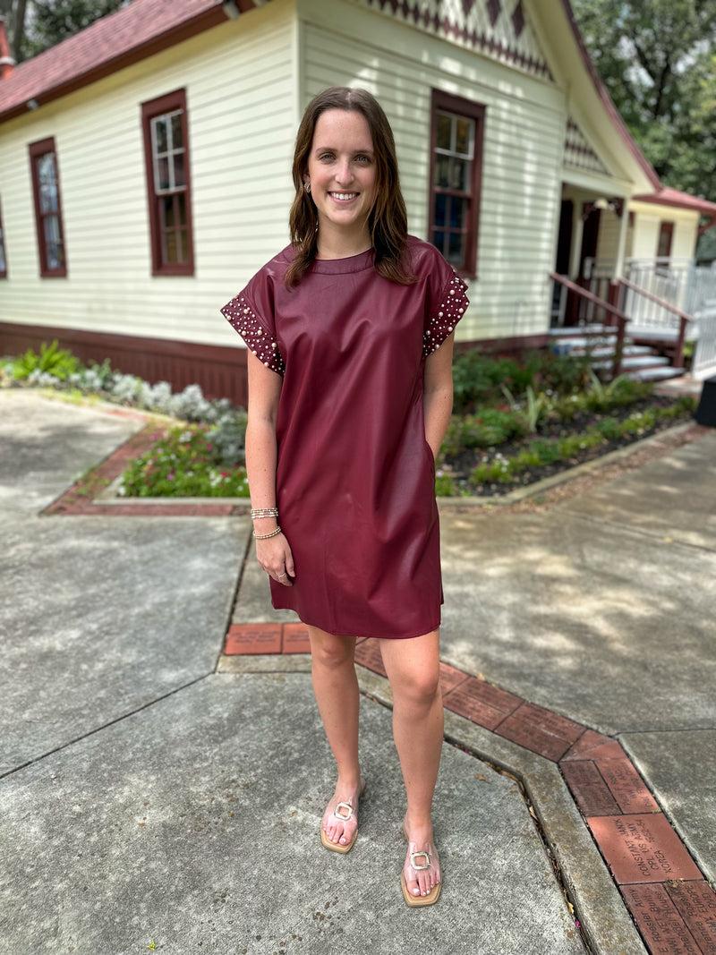 maroon leather style dress with pearl details on the sleeves 