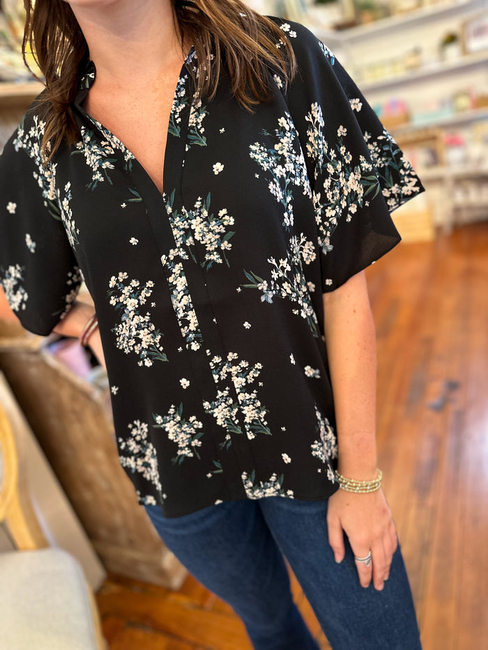 black polyester top with white floral accents