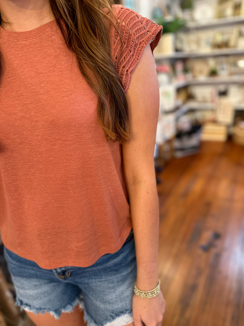 rust color top with crochet details on the sleeves