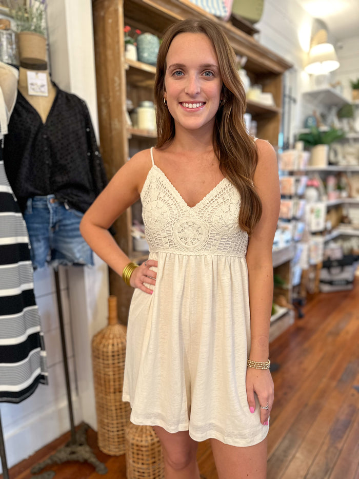 cream color romper with crochet details on the top