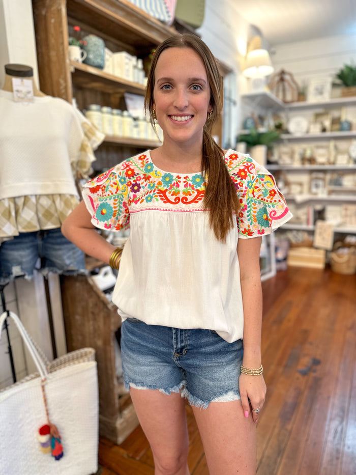 white layerz top with colorful embroidery details 